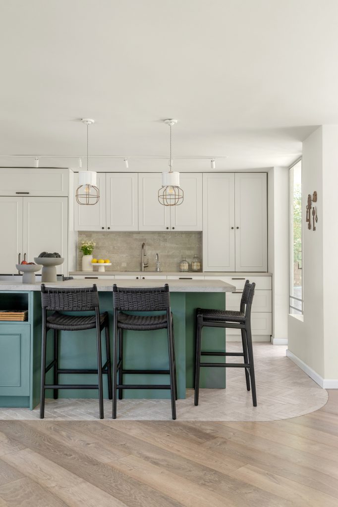 מטבח כפרי תעשייתי בגוונים לבן וירוק עם כיסאות שוחרים בשילוב עץ וחבל. 