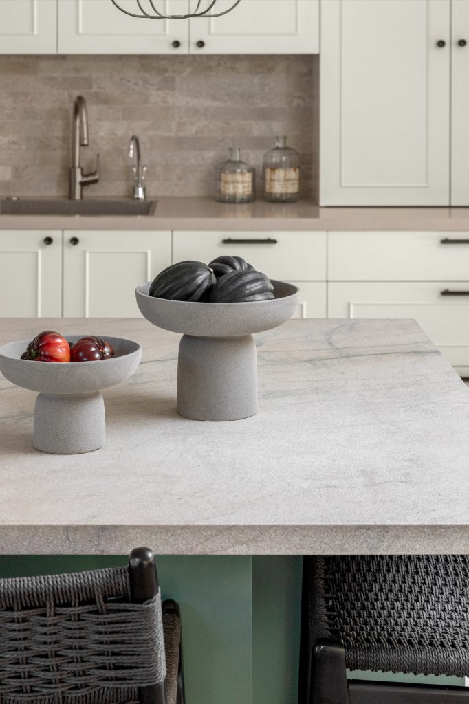 תקריב מטבח קוקו שאנל. אי ירוק, שיש גרניט טבעי וכיסאות בר בחבל שחור.