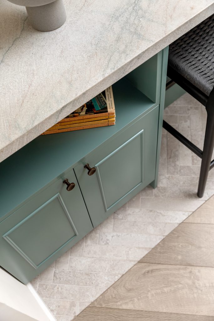 תקריב מטבח קוקו שאנל. אי ירוק, שיש גרניט טבעי וכיסאות בר בחבל שחור.